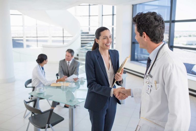 Doctor and businesswoman handshaking in meeting